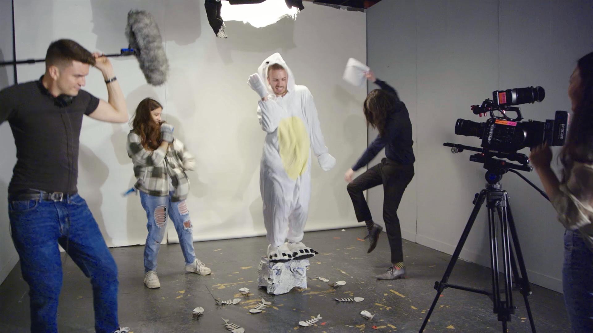 Film set crew dancing around a person dressed as a polar bear